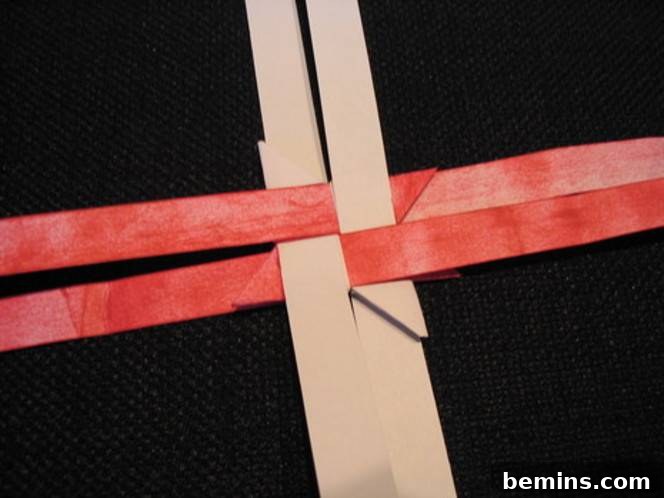 Two brown strips of paper interlaced with two red strips of paper. Repeating on the other side creates a symmetrical star.
