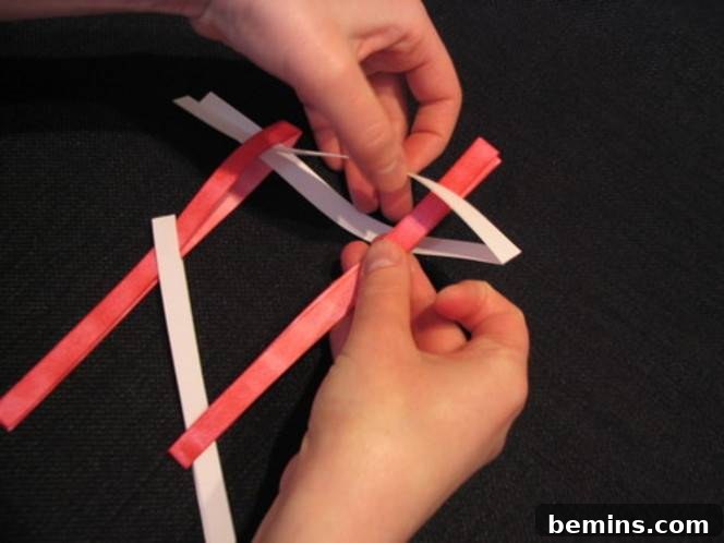 Strips of folded red and white paper are glued and fastened together to create an art piece. This is the foundation for your paper star.