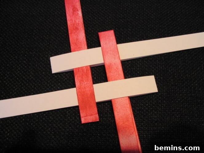 Red and pink ribbons are intertwined. Tightening the weave creates a secure base for the star.