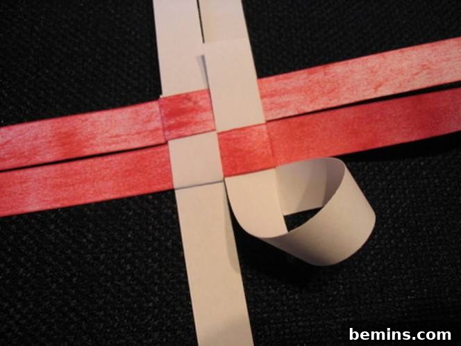 Pink and red ribbons are spread across a black surface. Repeating the process creates multiple points on one side of the star.