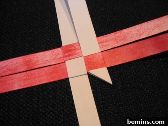 Pink and red ribbons criss cross on a black surface.
