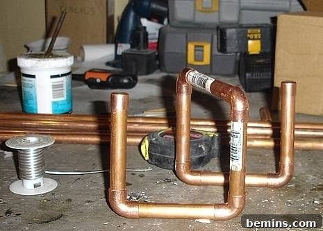 Crafting Copper Art Projects with New Soldering Skills 3 Initial dry-fit assembly of copper pipes and fittings on a workbench, resembling a simple functional design next to a toolbox.
