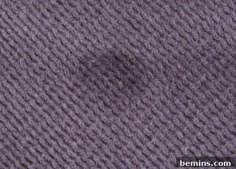 An oil stain on gray carpet, showing the type of stain this method can address.