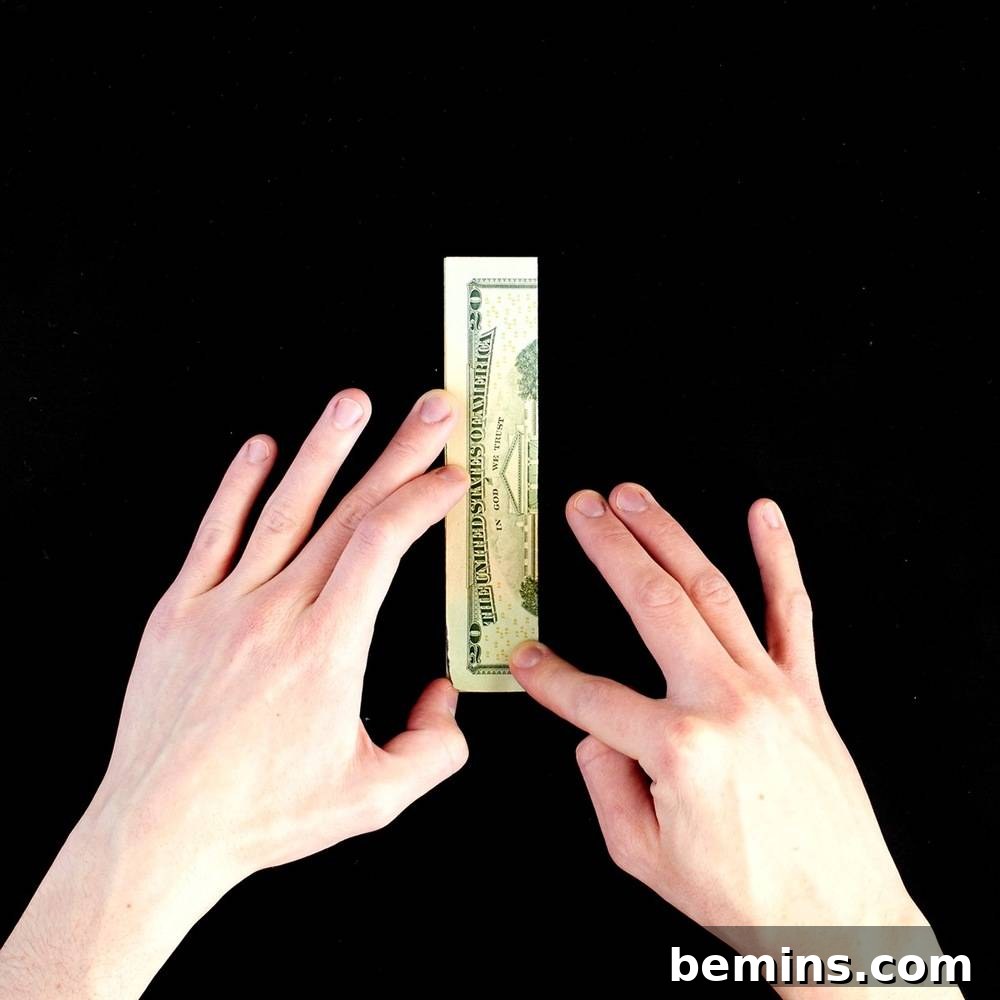 Folding the dollar bill in half lengthwise