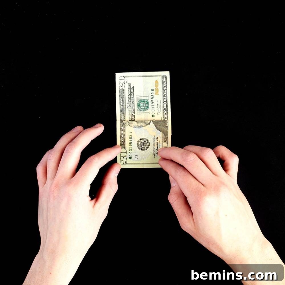 Folding the top layer of the dollar bill down
