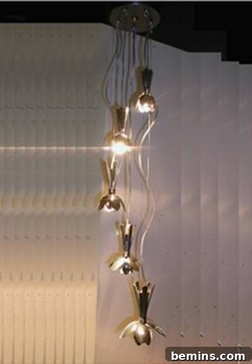 Sculptural light fixture made from spoons, hanging from the ceiling and creating a captivating visual display.