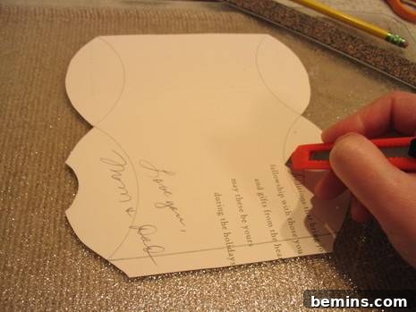 Scoring the lines on the greeting card with a sharp tool.