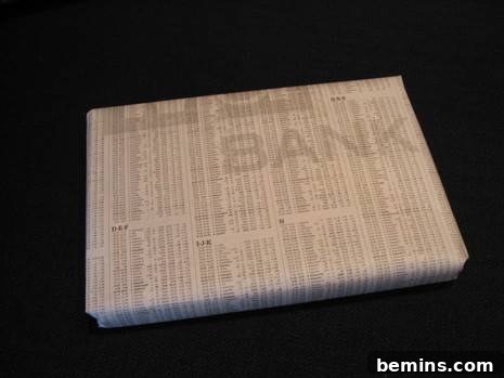 A book wrapped in newspaper featuring stock quotes.