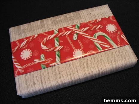 A book wrapped in plain wrapping paper with a strip of candy cane patterned wrapping paper.