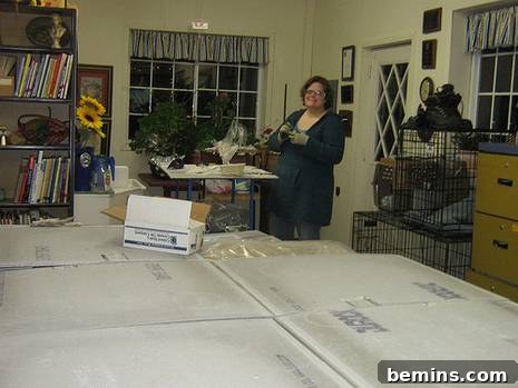 Woman is preparing giant mosaic mural in a room.