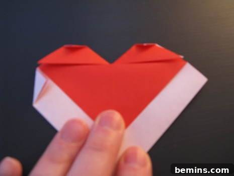Man preparing an origami heart envelope with color paper