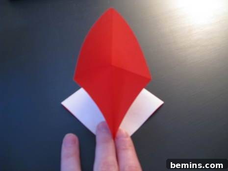 Folding a red and white paper into a heart-shaped envelope