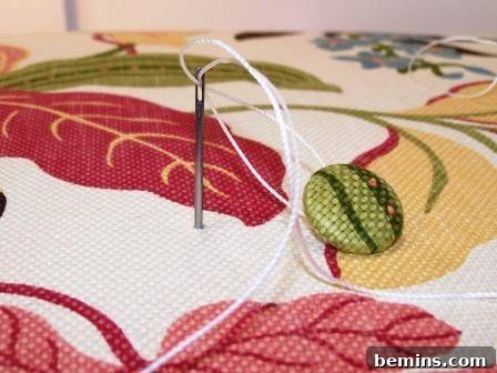 Preparing the covered buttons with twine for attachment.