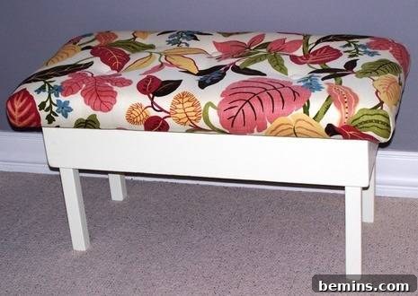 The finished upholstered bench, showcasing the beautiful fabric and covered buttons.