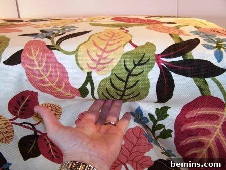 The fabric is carefully draped over the bench, ready for stapling.