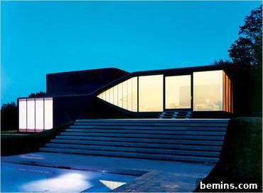 Exterior view of the UN Studio Villa at dusk, showing the mirrored glass effect