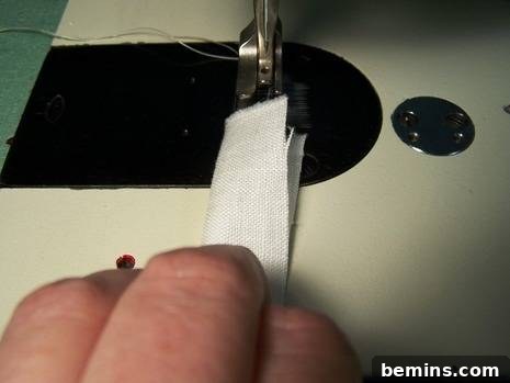 Using a zipper foot on a sewing machine to stitch closely alongside the enclosed cord