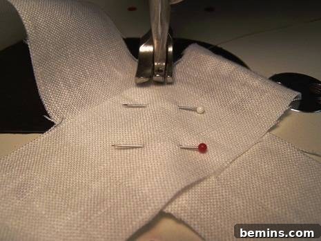 Two fabric strips aligned at a right angle, right sides together, ready for diagonal stitching