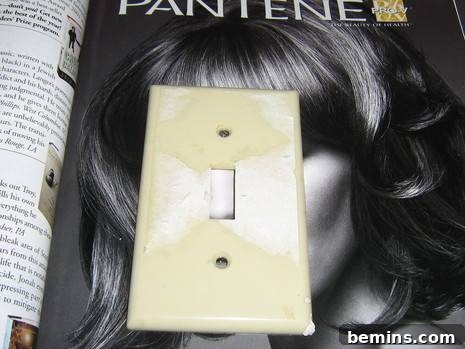 A light switch is sitting on a magazine ad.