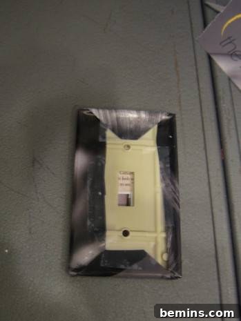 A light switch on the wall has a dark edge.
