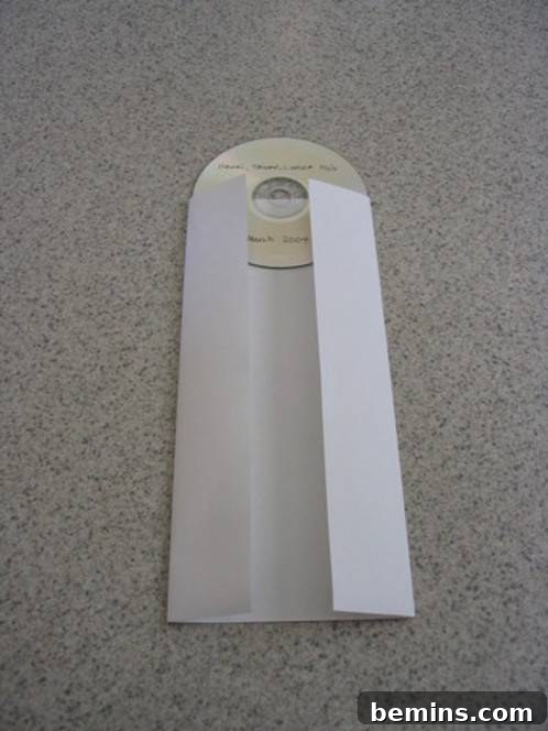 The sides of the paper are folded in, conforming to the shape of the CD.