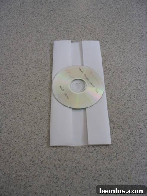 The CD is repositioned in the center of the folded paper.