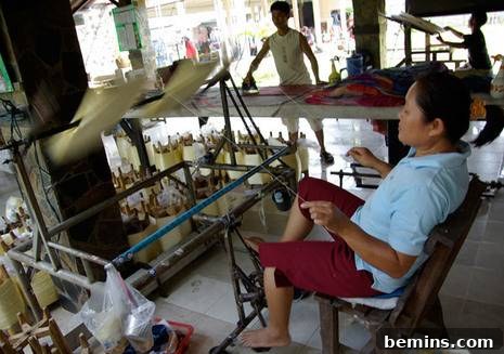 Crafting Silk The Essential 6 Steps 5 Artisan spinning naturally dyed silk threads on a traditional spinning wheel.