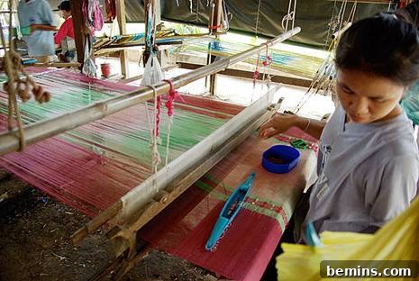 Crafting Silk The Essential 6 Steps 7 Skilled artisan weaving silk fabric on a traditional loom in Thailand.
