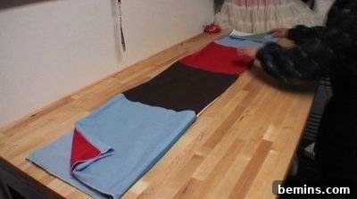 A person laying out multiple pieces of fabric. Preparing to Fold.