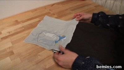 A person working with a white material on the floor. Attaching the Flap.