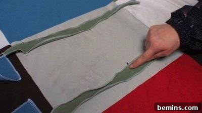 A person runs their finger down a green material. Attaching Ties.