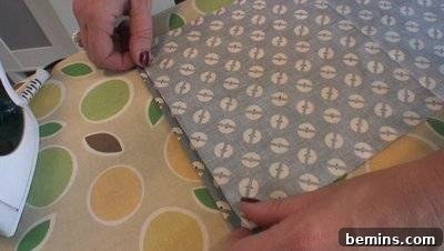 Two hands arranging a piece of blue patterned fabric.