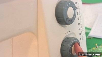 A person touching the switch of a sewing machine.