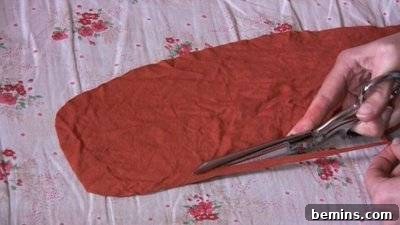 Person Using Scissors on Orange Material