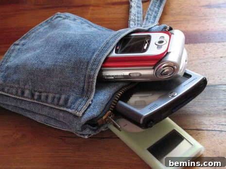 Three electronic devices sit in a denim pouch.