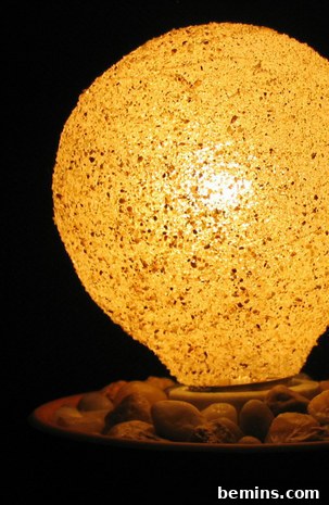 DIY Sanded Light Bulb 2 Light bulb with sand glaze in saucer filled with small rocks.