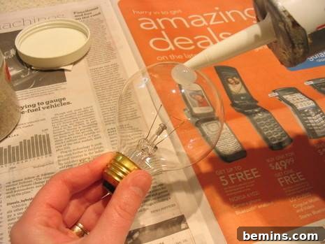 DIY Sanded Light Bulb 4 "A person is applying Glue to make a Sanded Bulb"