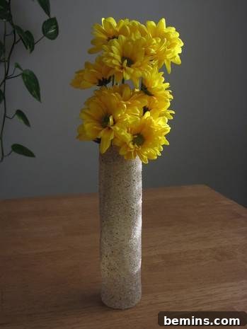 DIY Sanded Light Bulb 9 Bouquet of flowers in tall, thin vase on top of a table.