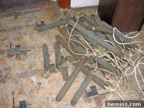 A pile of cast-iron window weights on an old linoleum floor, salvaged from a historic window replacement project.