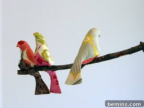 Three colorful dove statues perched on a branch, showcasing artistic detail and tranquil beauty.
