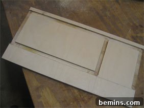 A wood board with precisely cut grooves, ready for assembly.