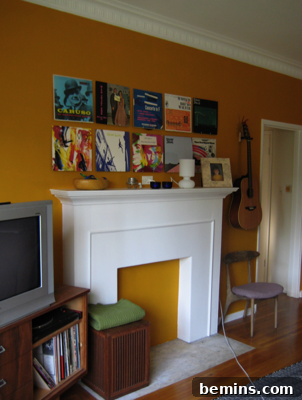 A blocked up fire place with many framed albums and a guitar near it.