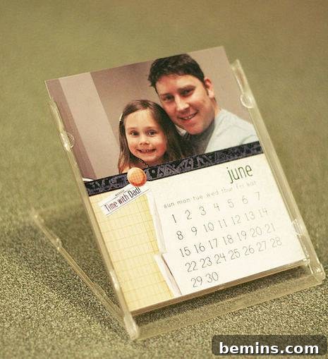 A calendar in a holder that is showing a dad and his daughter.