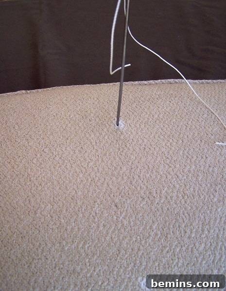 DIY Mod Upholstery: Faux Tufting Techniques 7 Pulling the twine through the cushion to the back