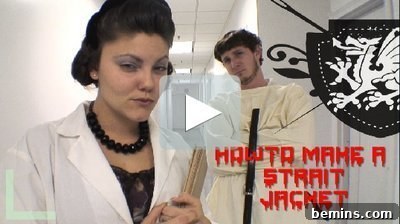 A woman with black hair and a black necklace in front of a man in a white straitjacket.