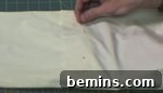 A person putting pins into fabric.