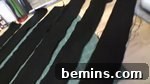 Several black strips of fabric lay across a floor, ready to be ruched.