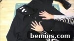 A black shirt with two hands on it, preparing to remove the sleeves.