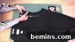 Woman cutting black cloth into pattern, creating the design for the sleeves.
