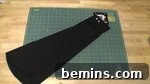 A dark fabric on top of a table, showcasing the material for the sleeves.